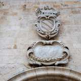 ul grande portone � affisso lo stemma dei Filomarino sormontato da un angelo che regge un cartiglio con su scritto �sat unus�. Immediatamente sotto, un altro elemento decorativo sembra rappresentare una clessidra con i simboli dello zodiaco